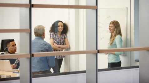 two women and a man standing in front of a whiteboard
