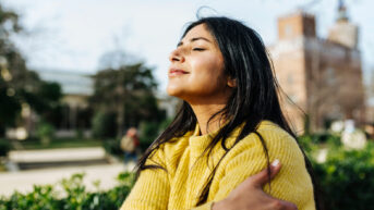 a woman in a yellow sweater is looking up