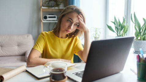 a woman sitting in front of a laptop computer
