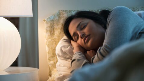 a woman sleeping in bed with her head on the pillow