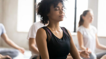 a group of people doing yoga in a room