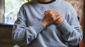 a woman sitting in a chair with her hands folded