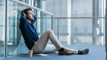 a man sitting on the ground with his headphones up