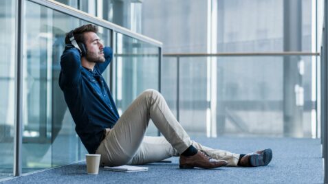 a man sitting on the ground with his headphones up