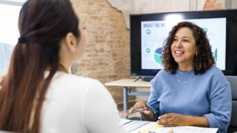 a woman sitting at a table with a cell phone