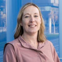 a woman standing in front of a blue building