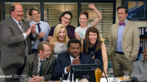 a group of people standing around a computer