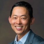 a man in a suit smiling for a photo