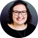 a woman wearing glasses and smiling for the camera