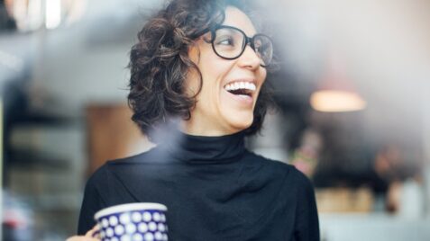 a woman with glasses holding a coffee cup