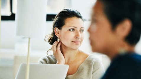 a woman sitting in front of a laptop computer