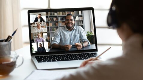 a man is on a laptop with other people in the background