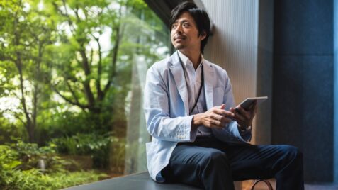 a man sitting on a ledge looking at something