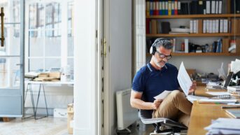 a man sitting in a chair reading a paper
