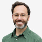 a man wearing glasses and a green shirt