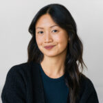 a woman sitting on a couch wearing a black cardigan