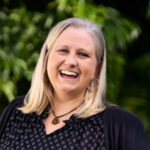a woman with blonde hair smiling at the camera