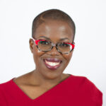 a woman wearing glasses and smiling for the camera