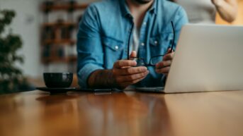 a man sitting at a table using a laptop computer