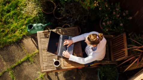 a woman sitting at a table with a laptop