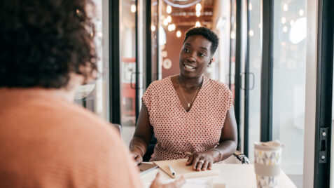 a woman sitting at a table in front of a window