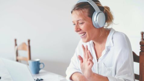 a woman wearing headphones sitting in front of a computer