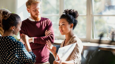 two women and a man sitting at a table