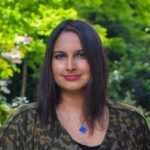 a woman with long dark hair wearing a black shirt