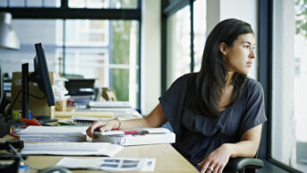 Hispanic woman sitting at a desk in an office