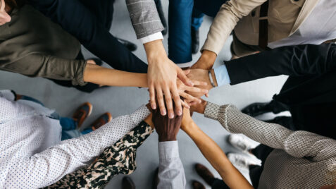 a group of people putting their hands together