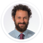 a man with a beard wearing a blue shirt and tie