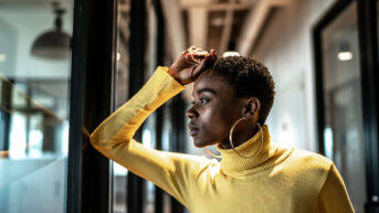 a woman in a yellow turtle neck sweater