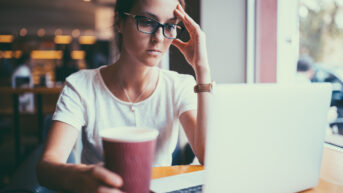 a woman sitting in front of a laptop computer