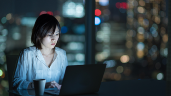 a woman sitting in front of a laptop computer