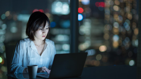 a woman sitting in front of a laptop computer