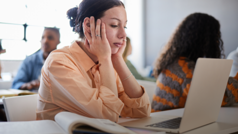 a woman sitting in front of a laptop computer