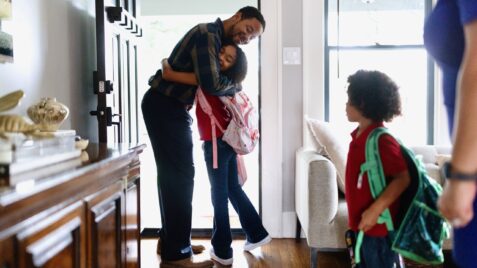 Back to school: Parent hugging child goodbye at beginning of school day