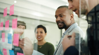 a group of people standing around a glass wall