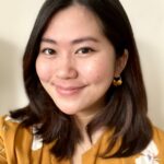 a woman in a yellow shirt smiles at the camera