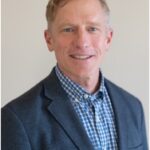 a man in a suit smiling for the camera