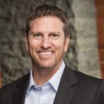 a man in a suit smiling for the camera