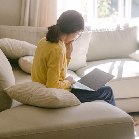 a woman sitting on a couch reading a book