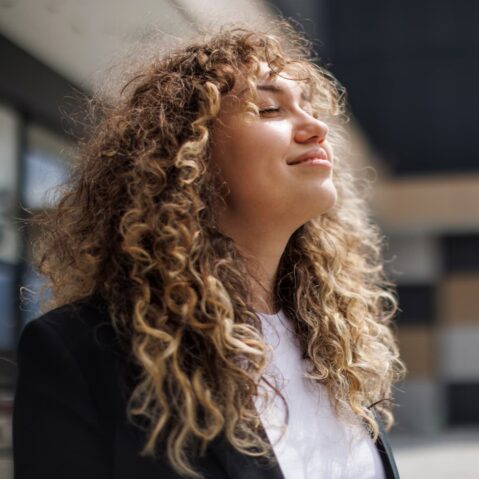 a woman with curly hair is looking up