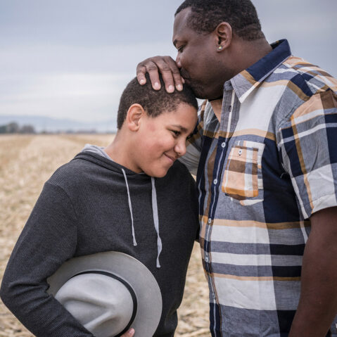 a couple of men standing next to each other in a field