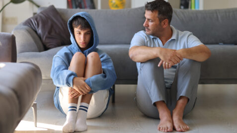A father and son sitting on the floor - teen mental health