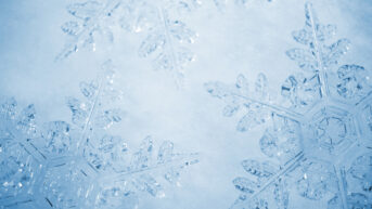 a close up of a snowflake on a blue background