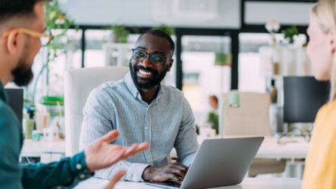 A group of consultants at a business services firm seated at an office table