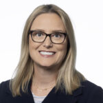 a woman wearing glasses and a black jacket