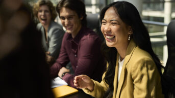 a group of people sitting around a table laughing